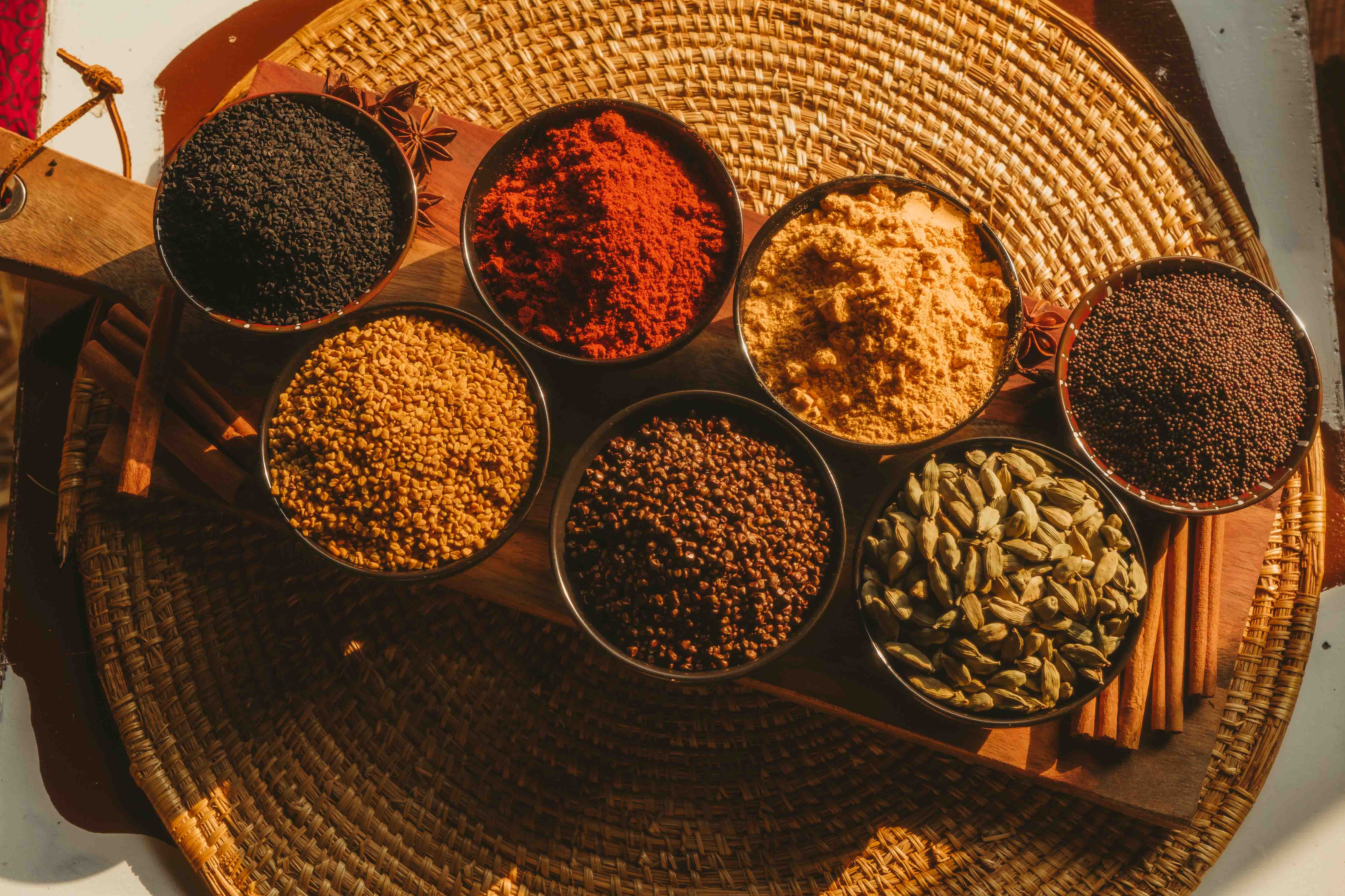Colourful Abyssinian spices arranged in bowls on a woven tray